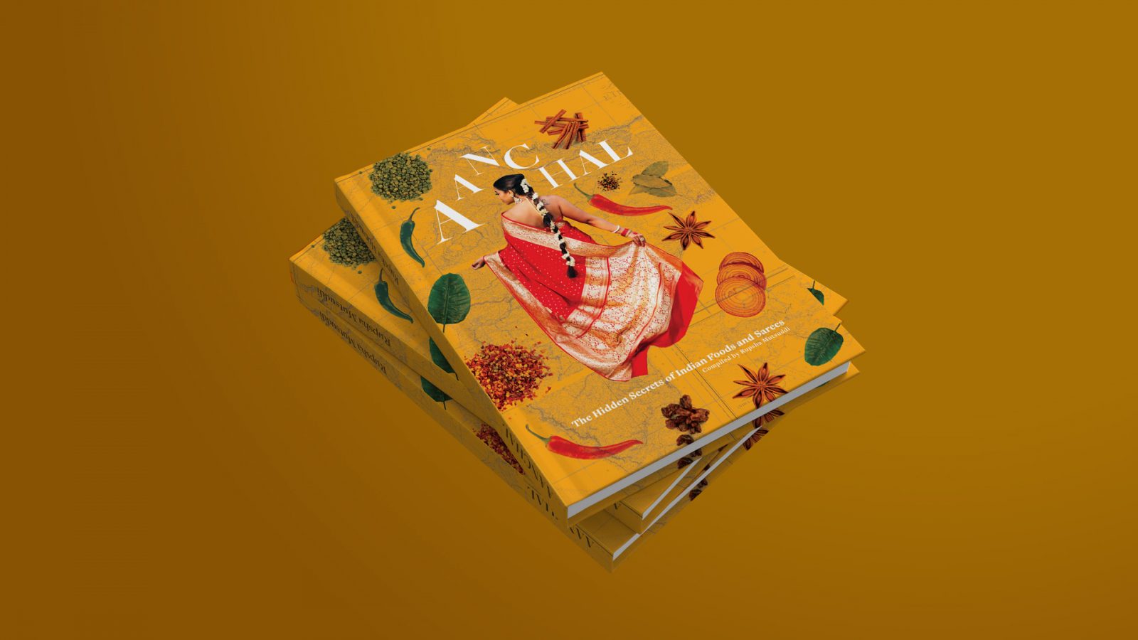 The cover for Aanchal: The Hidden Secrets of Indian Foods and Sarees features an Indian woman on the cover wearing a red saree that drapes across her back. She is surrounded by different ingredients used in Indian cuisine which is then layered atop a map of India. The book is an exploration of the cultural mosaic of the Indian subcontinent using the saree as a storytelling vehicle.