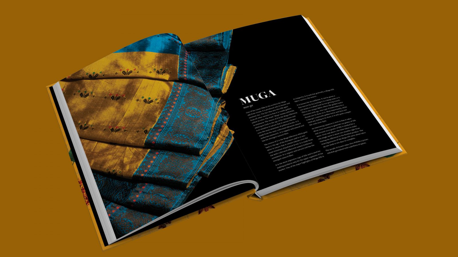 An interior spread from the book Aanchal: The Hidden Secrets of Indian Foods and Sarees which shows a Muga saree fanned out against a black background. The saree is blue and gold with black and red patterning and lustrous in quality. The Muga saree hails from the state of Assam in India.