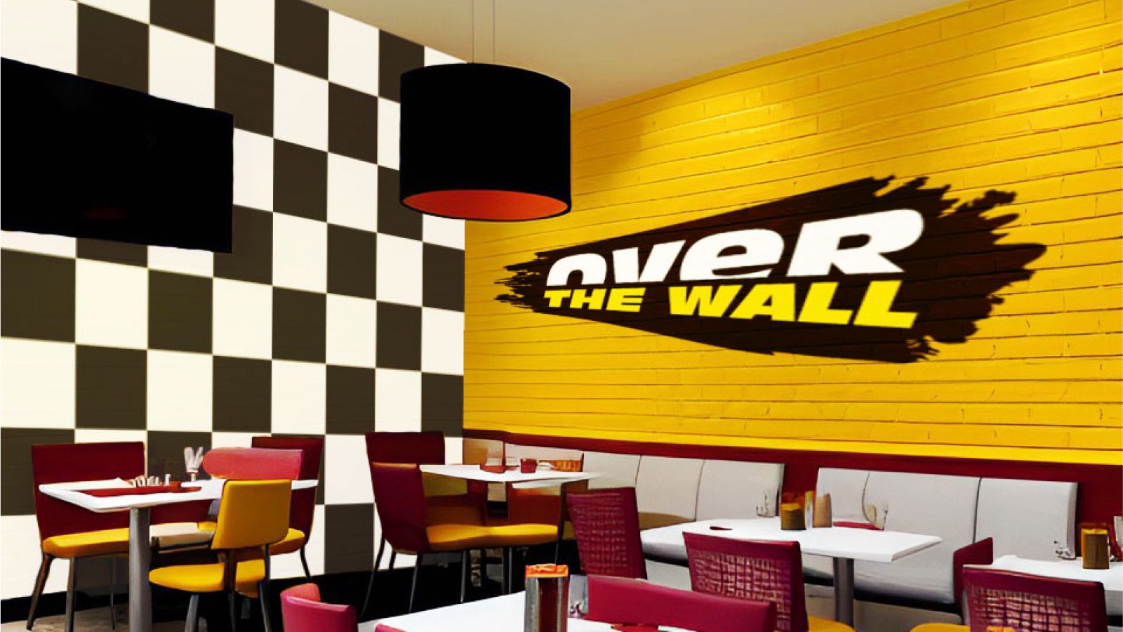 Restaurant interior with one yellow brick wall and one checkered flag style wall.