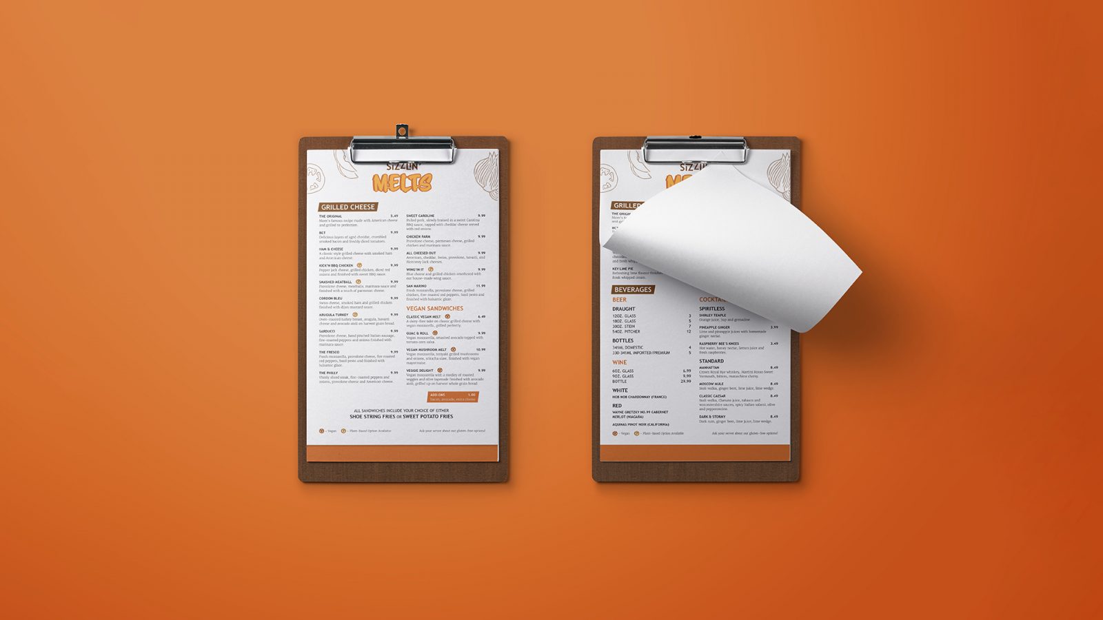 Two menus on clipboards for the restaurant Sizzlin’ Melts. The first clipboard has the sandwich listings, and the second clipboard has the page flipped to the soup and drink menu.